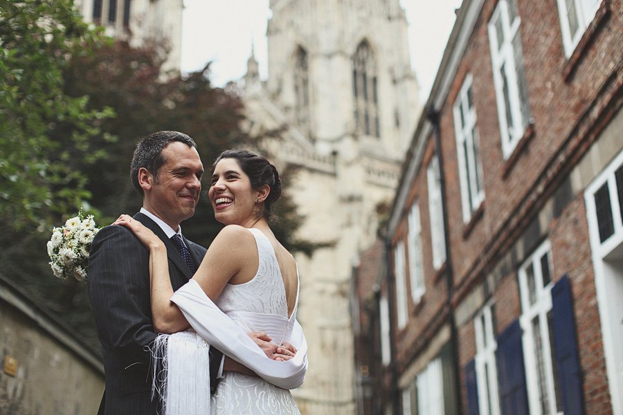 Bride and groom embracing on historic city street