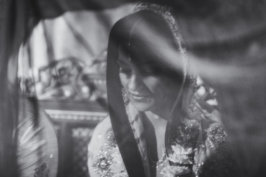 Bride wearing veil and floral garland indoors