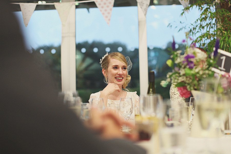 Bride smiling at wedding reception table