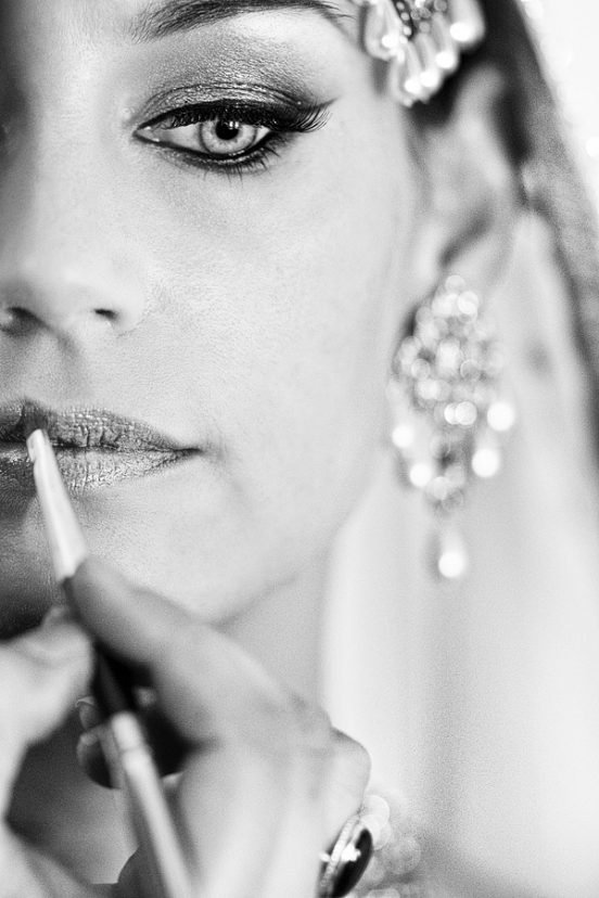 Black and white close-up of woman applying lip liner