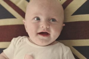 Smiling baby lying on Union Jack flag