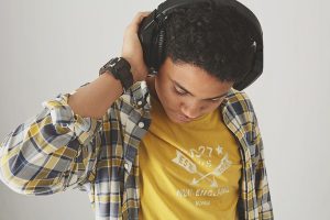 Young person wearing headphones and plaid shirt