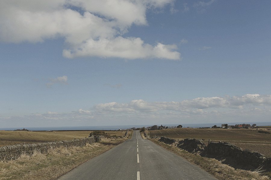 Long rural road under blue sky