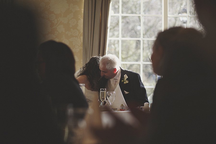 Bride and older man sharing quiet moment indoors