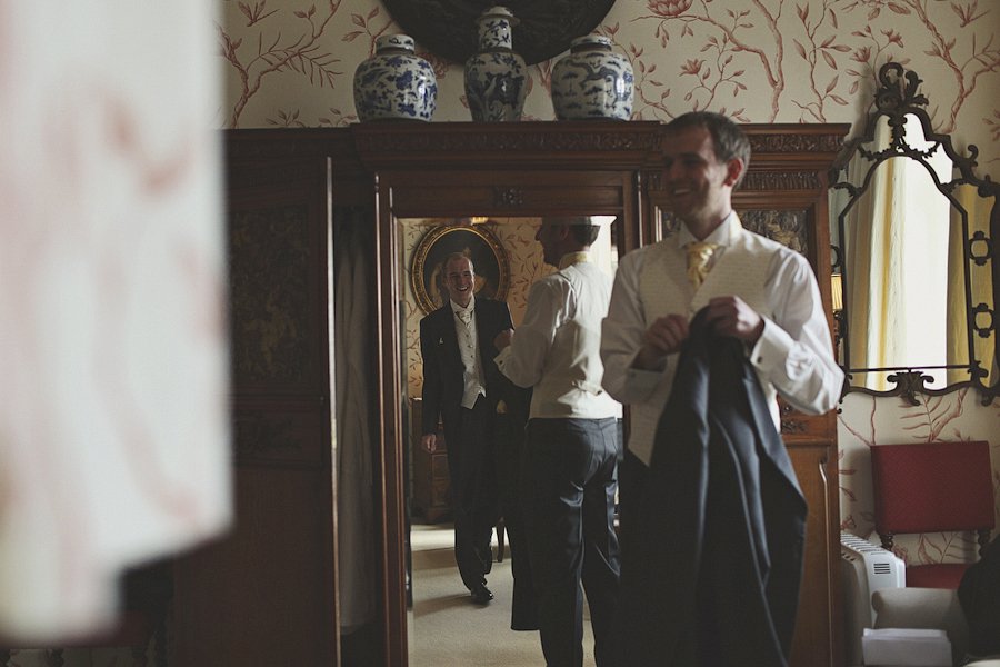 Man in formal suit adjusting jacket indoors