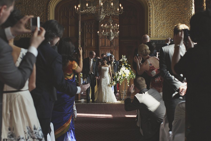 Bride and groom walking down ornate wedding aisle