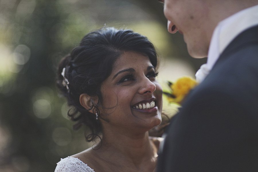 Bride smiling at groom during outdoor wedding.