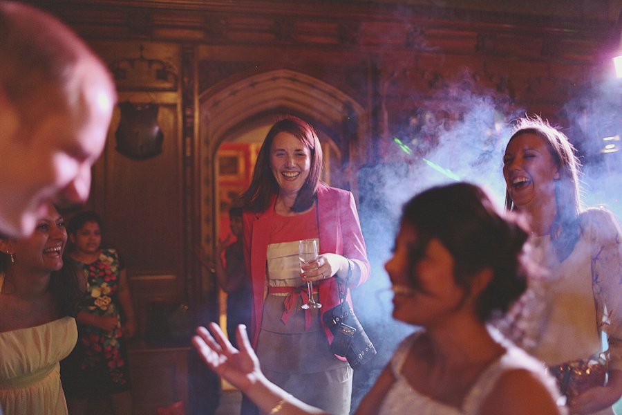 Women laughing at indoor party with drinks