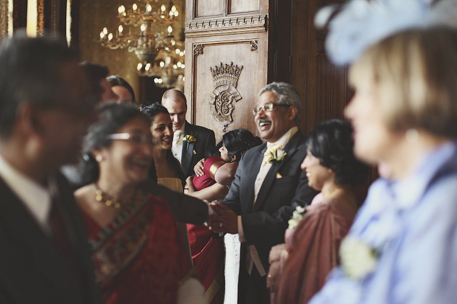 Wedding guests greeting couple in ornate venue