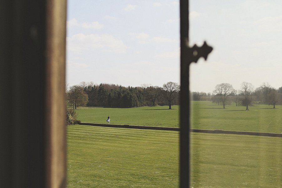 View of green field through window