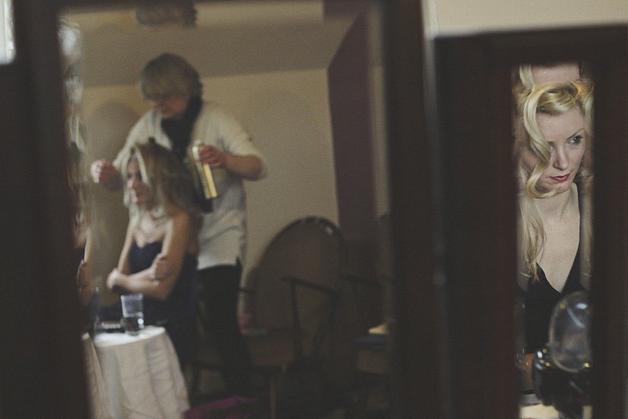 Woman getting hair styled in front of mirror