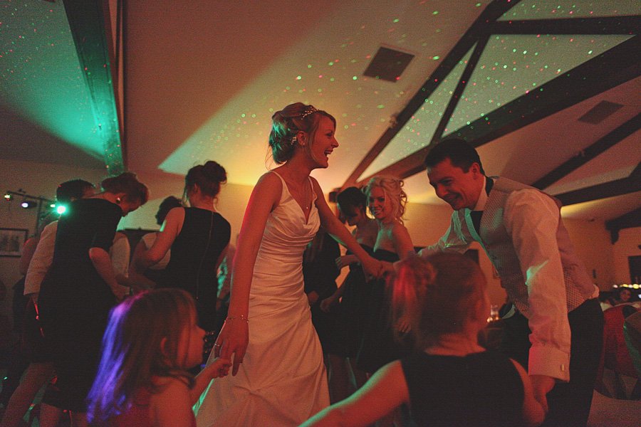 Bride and groom dancing with children at reception