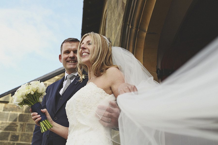 Bride and groom smiling outside church entrance