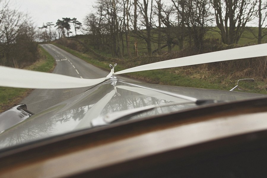 Rolls-Royce hood ornament on rural road