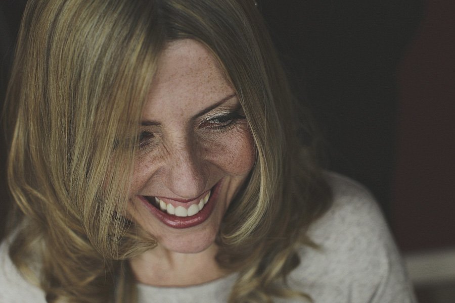 Smiling blonde woman looking down indoors