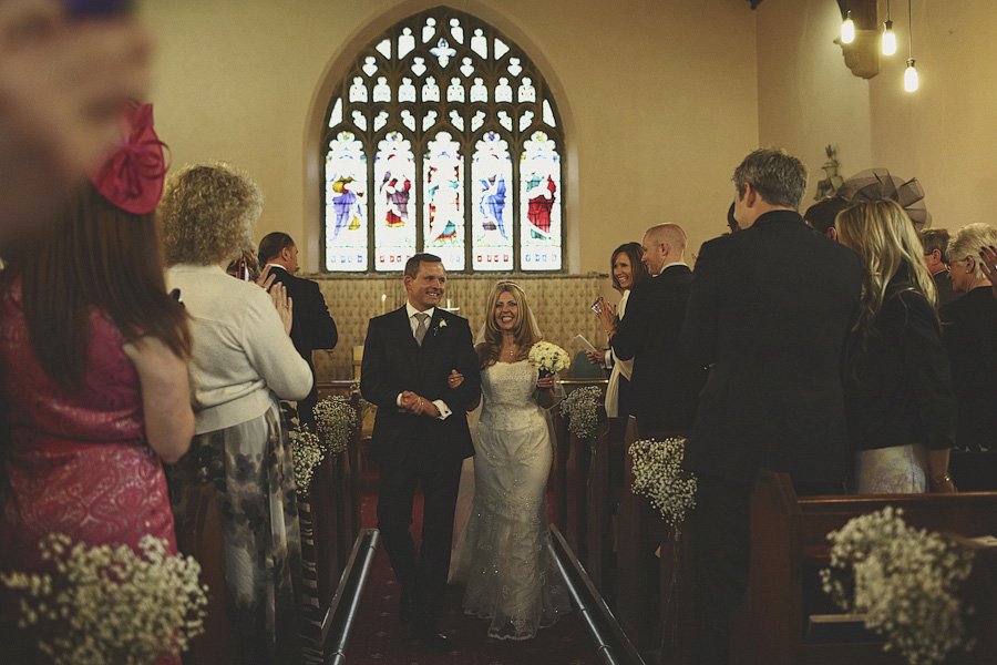Bride and groom walking down church aisle