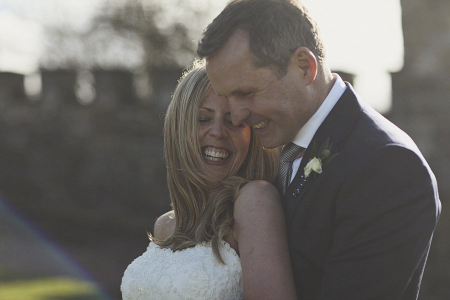 Bride and groom embracing outdoors at sunset