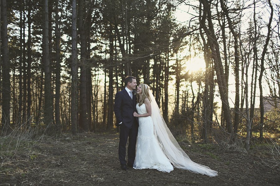 Bride and groom in forest at sunset