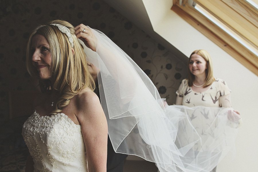 Bride having veil adjusted before wedding ceremony