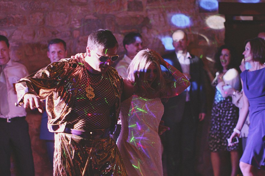 Man in gold costume dancing with bride