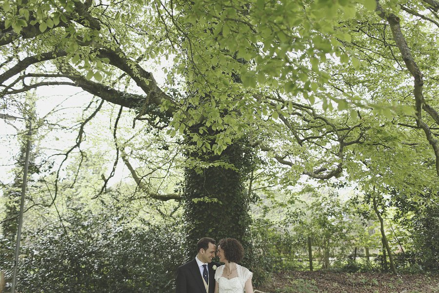 Bride and groom under large leafy tree