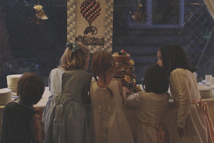 Children gathered around tall dessert display indoors