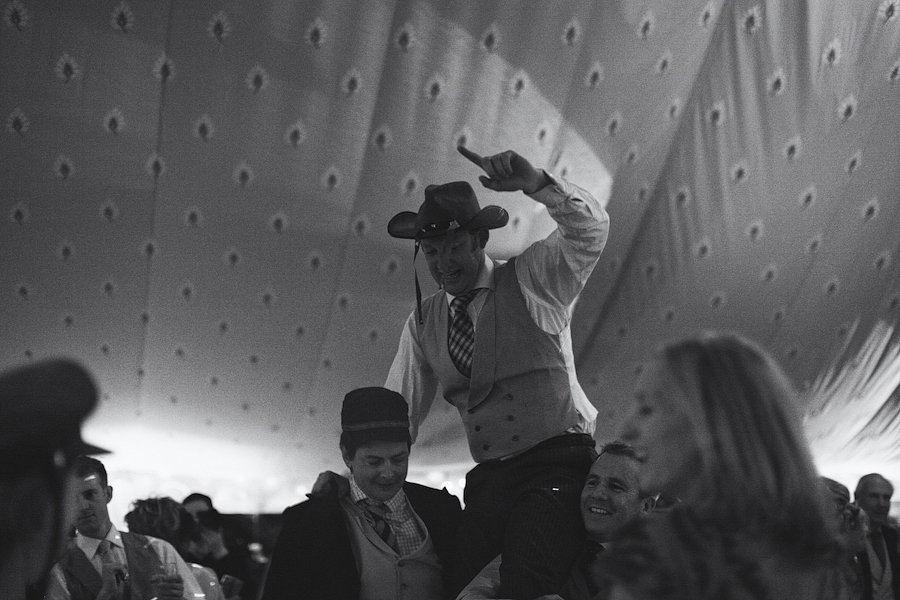Man in cowboy hat lifted at party