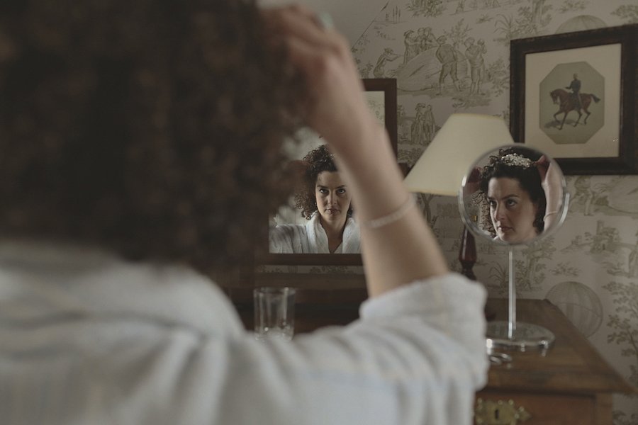 Woman adjusting hair in vanity mirror