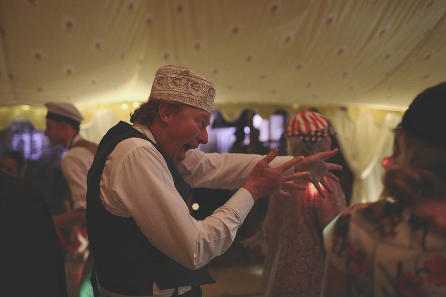 Man dancing energetically at tented celebration