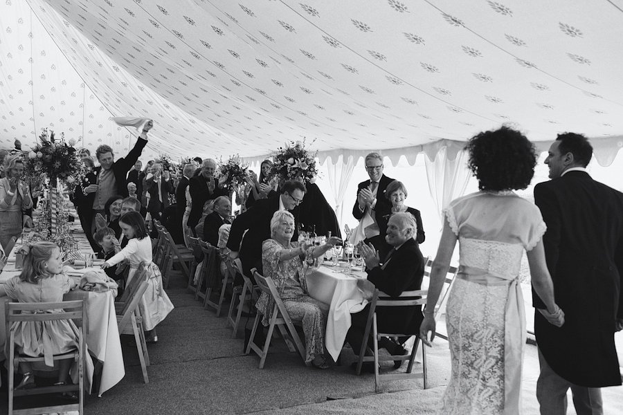 Bride and groom enter wedding reception tent