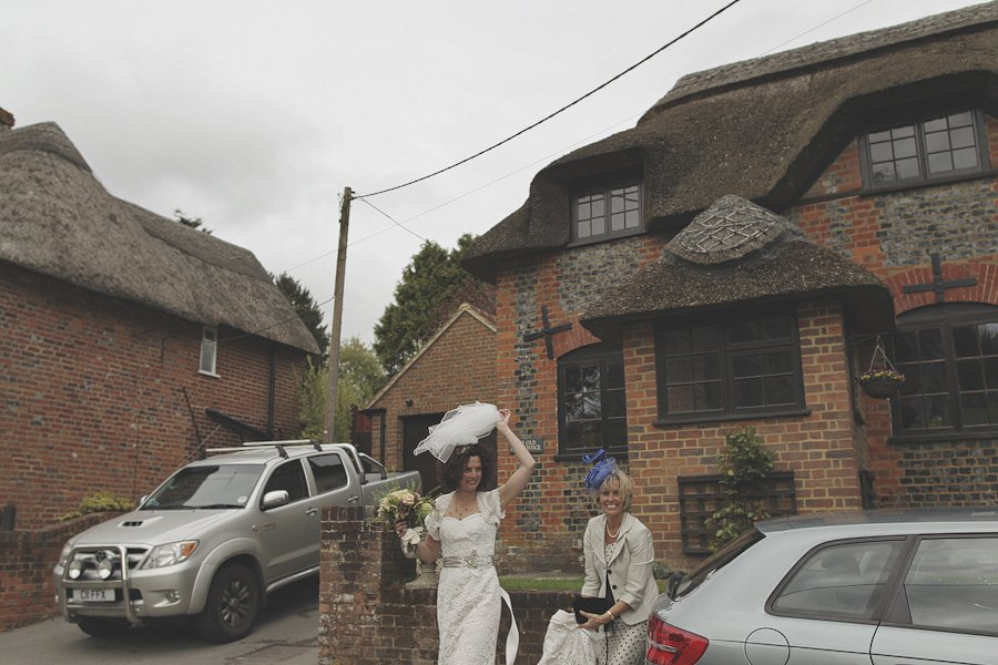 Bride and guest outside rustic brick cottages
