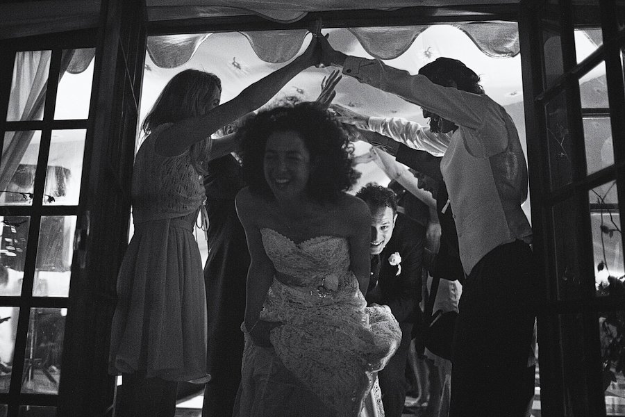 Bride and groom running through wedding guests