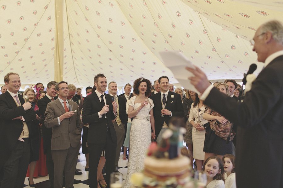 Wedding guests laughing during heartfelt reception speech