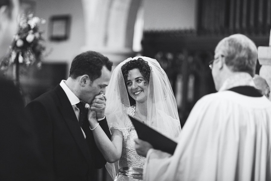 Groom kisses bride’s hand during wedding ceremony
