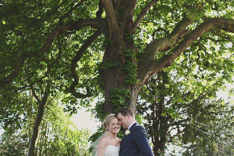 Bride and groom under large leafy tree