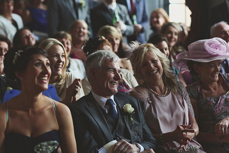 Wedding guests laughing during indoor ceremony