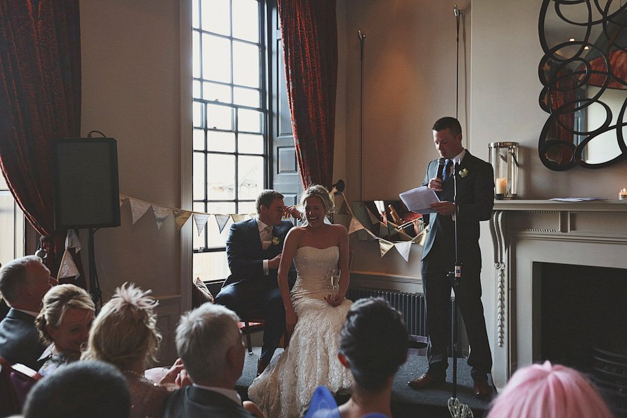 Groom whispering to bride during wedding speech