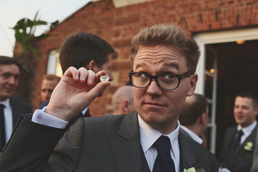 Man in suit holding small round object outdoors