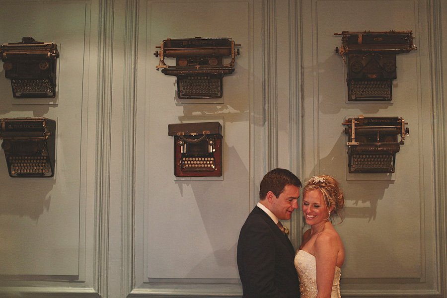Bride and groom beneath vintage typewriters display