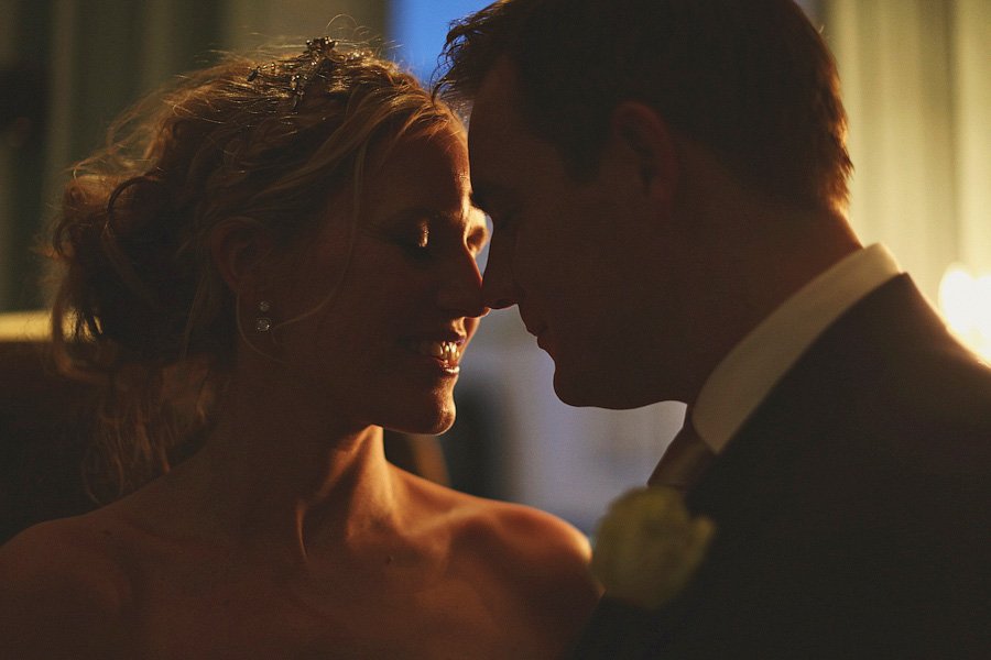 Bride and groom touching foreheads in warm light