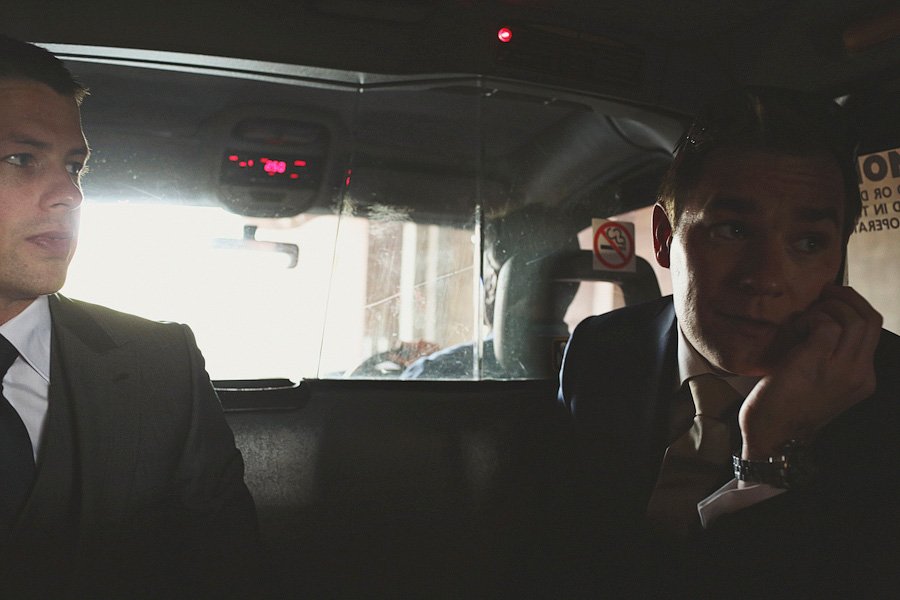 Two men in suits riding in a taxi