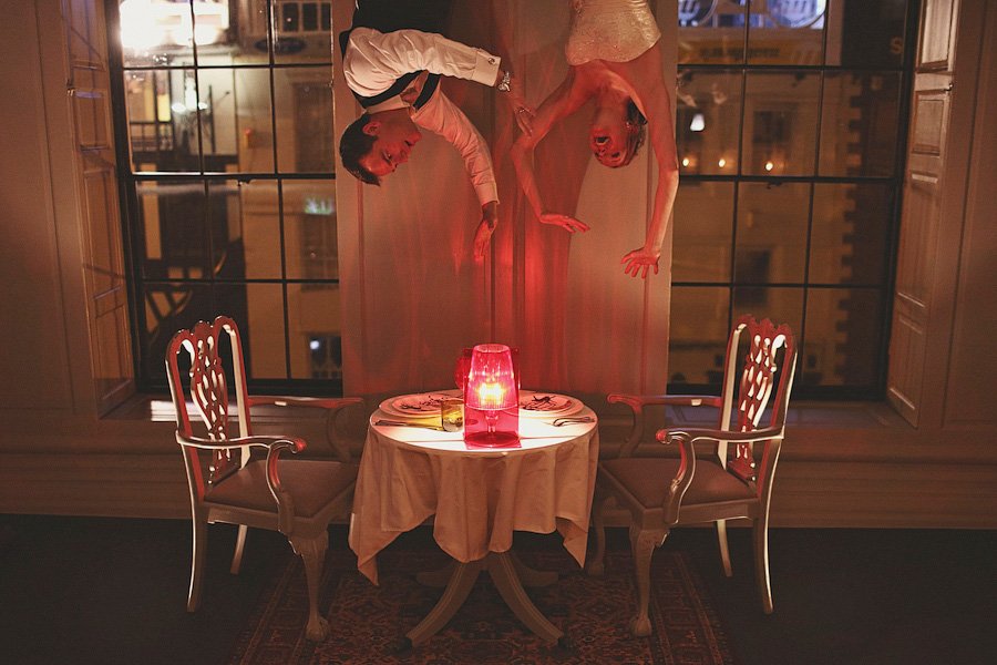 Upside-down couple over candlelit dinner table
