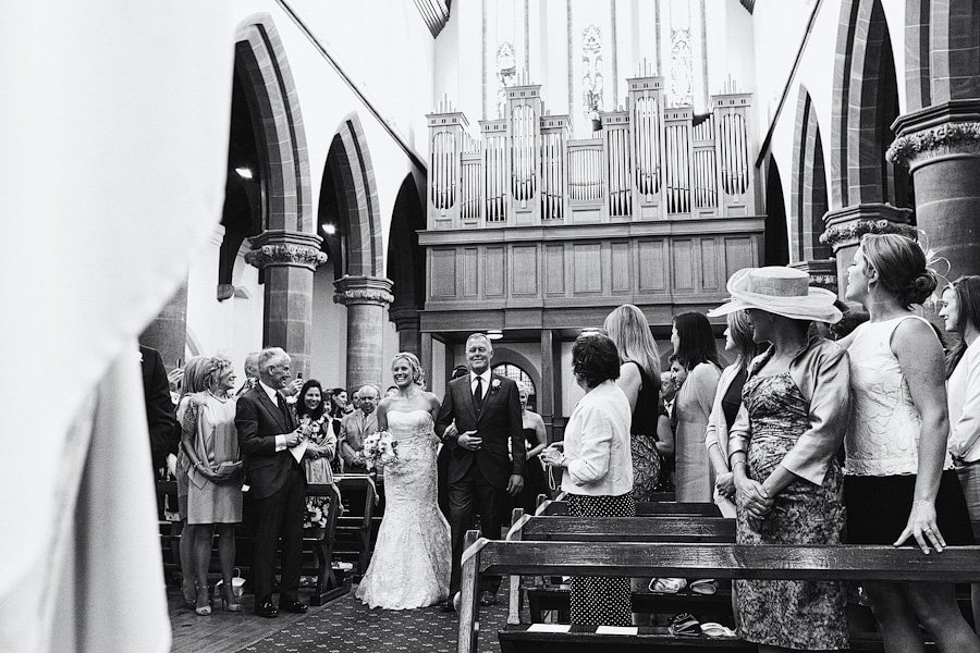 Bride and groom walking down church aisle