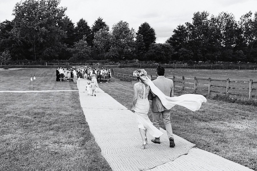 Bride and groom walking outdoor wedding aisle