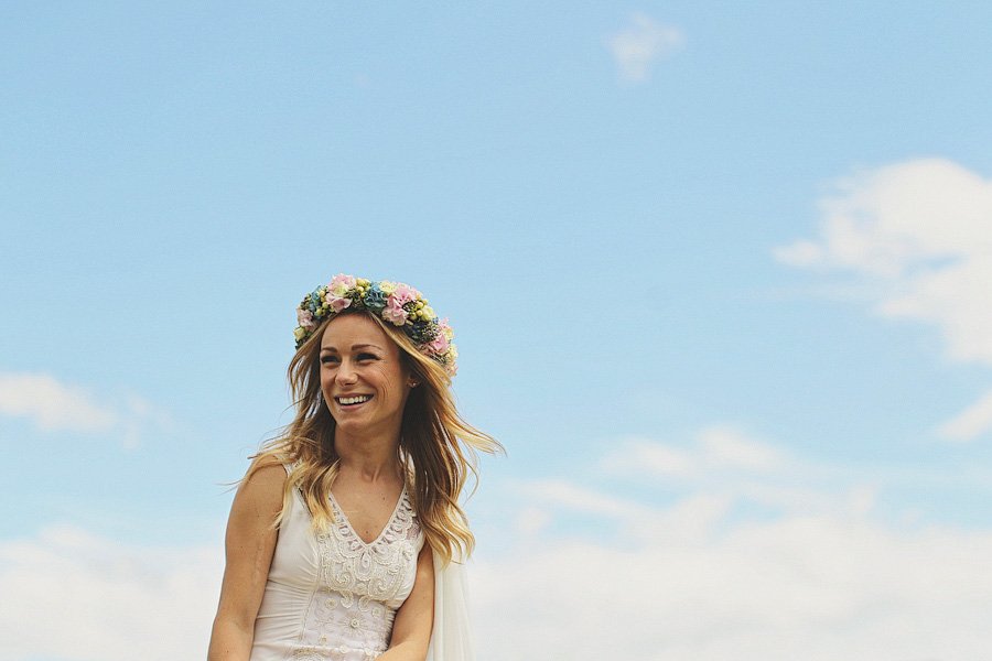 Smiling woman wearing flower crown under blue sky