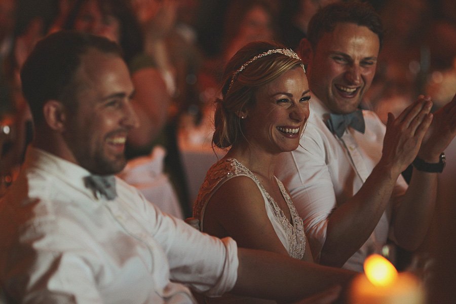 Guests laughing and clapping at wedding reception