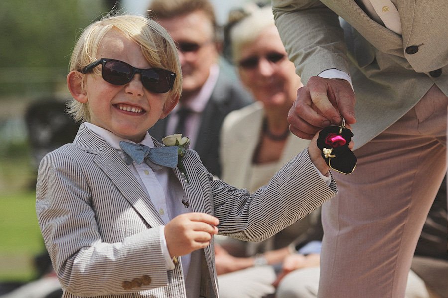 Smiling boy in suit holding wedding ring box