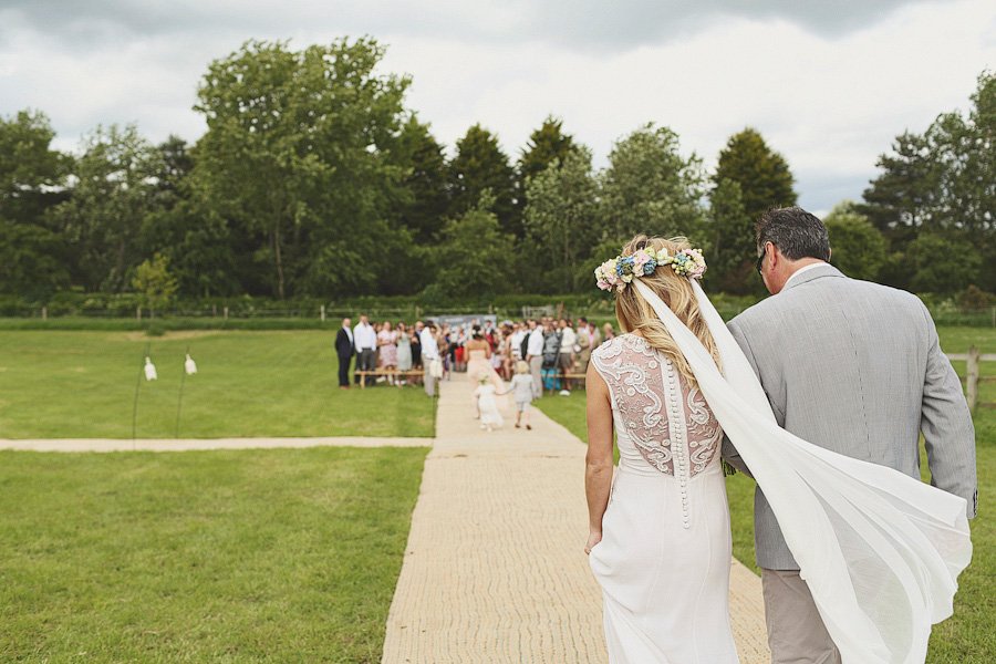 Bride walking down outdoor aisle with father