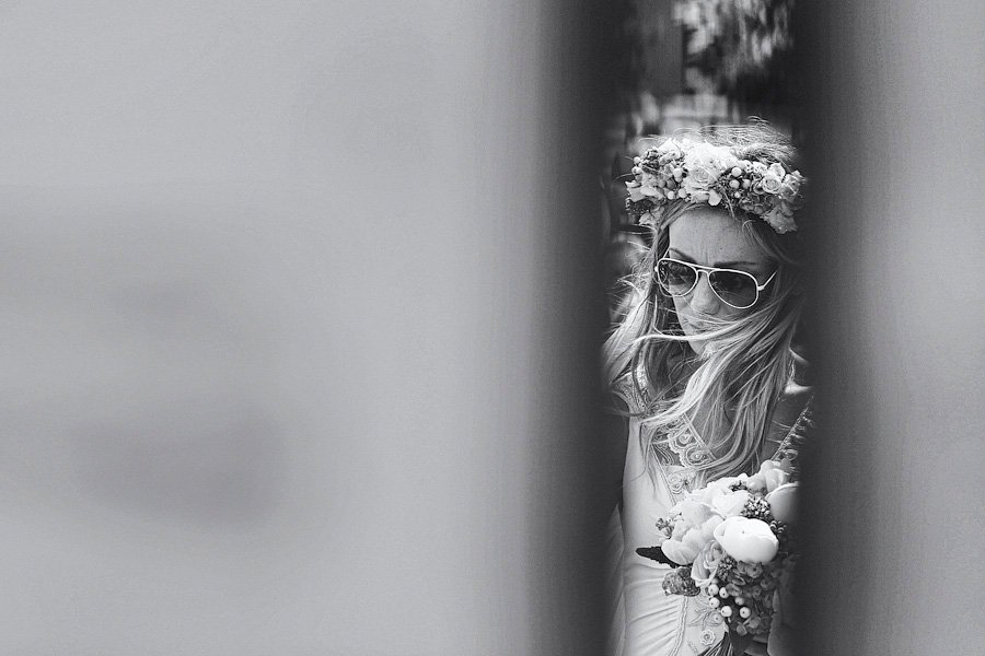Bride with flower crown and sunglasses holding bouquet