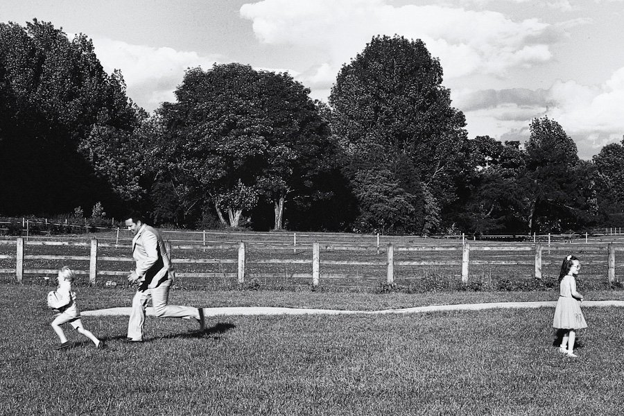 Man chasing child in grassy park